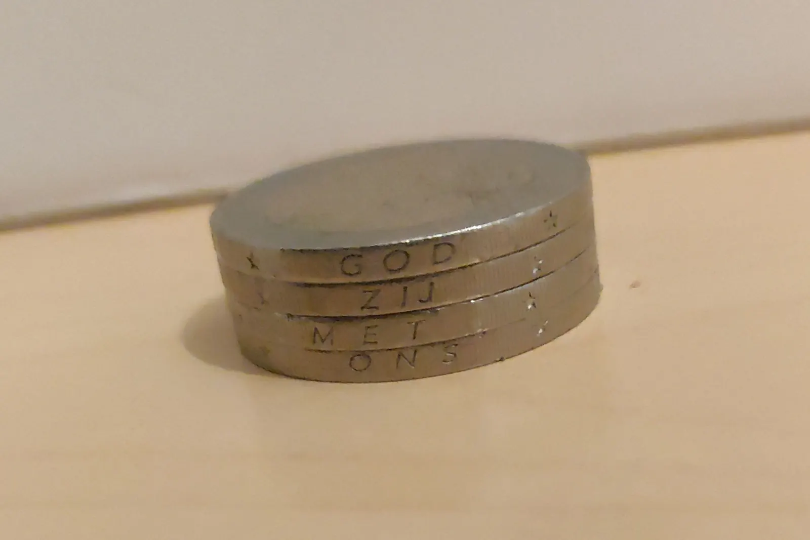 Pile de pièces de 2 € des Pays-Bas vues par la tranche, où est gravée l'inscription GOD ZIJ MET ONS.